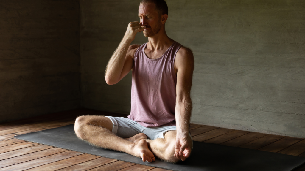 Man performing breathing exercise on a Yoga mat.